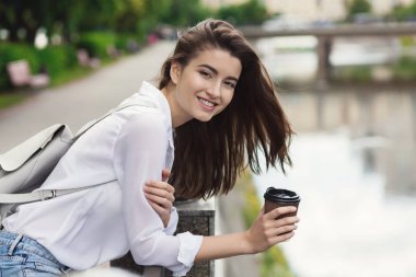 Mutlu kadın waterfront Nehri üzerinde kahve içme