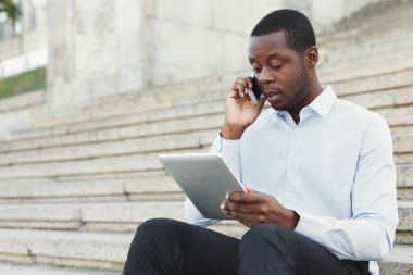 Afrika kökenli Amerikalı işadamı açık havada tablet ile çalışma