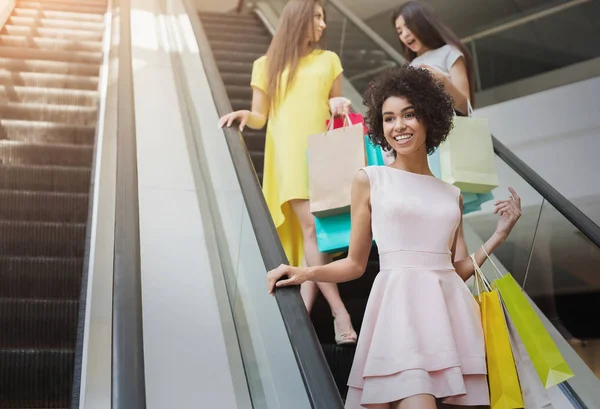 Glada multiracial tjejer på rulltrappa i gallerian — Stockfoto