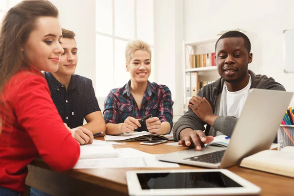 Grupy z różnych studentów studiujących w drewniany stół — Zdjęcie stockowe