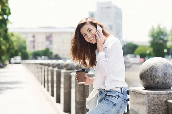 Szczęśliwa dziewczyna rozmawia na smartphone, stojąc na zewnątrz — Zdjęcie stockowe