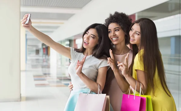 Mujeres felices tomando selfie mientras compran en el centro comercial — Foto de Stock