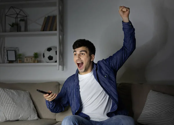 Worried man watching football at home