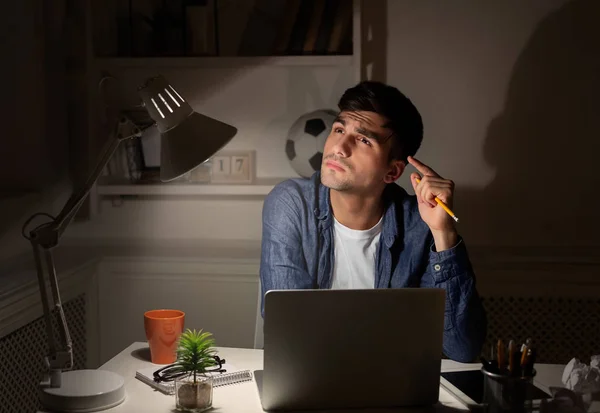 Στοχαστικός άνθρωπος με φορητό υπολογιστή στο γραφείο στο σπίτι το βράδυ — Φωτογραφία Αρχείου