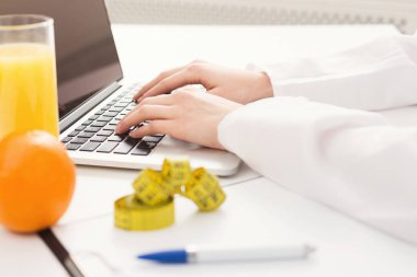 Dizüstü bilgisayarda çalışan kadın beslenme uzmanı