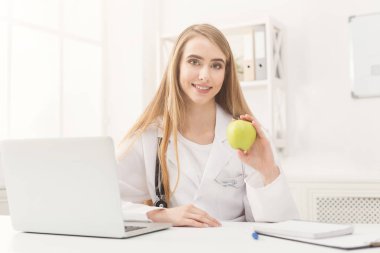 Gülümseyen beslenme uzmanı kadın ofiste apple ile