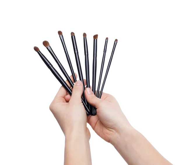 Set di pennelli per il trucco nelle mani della donna isolate — Foto Stock