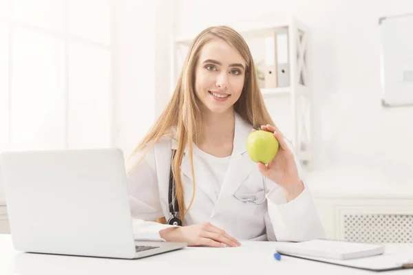 Lachende voedingsdeskundige vrouw met apple op kantoor — Stockfoto