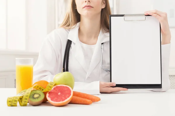 Doctor nutritionist holding blank clipboard — Stock Photo, Image