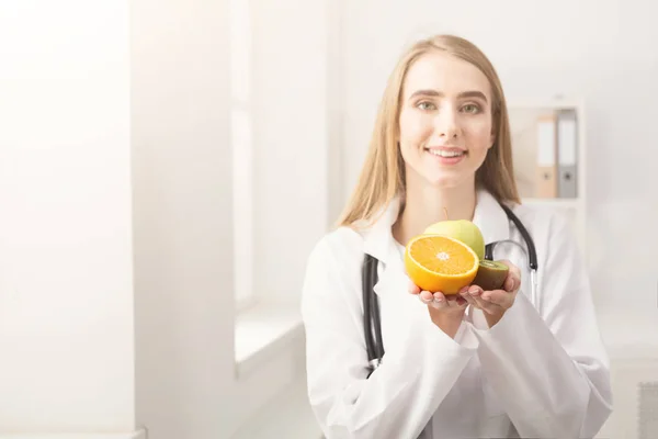 Gülümseyen beslenme uzmanı kadın ofiste meyve ile — Stok fotoğraf