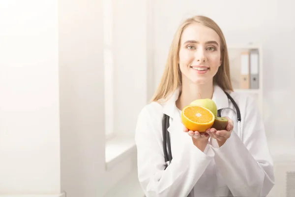 Femme nutritionniste souriante avec des fruits au bureau — Photo