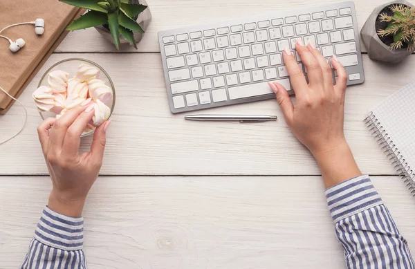 Frau isst Bonbons am Arbeitsplatz, von oben — Stockfoto