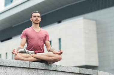 Lotus poz şehirde oturan beyaz adam