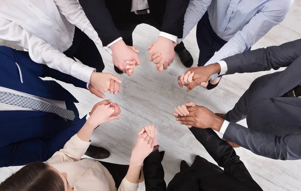 Business colleagues holding hands together, top view — Stock Photo, Image