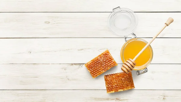 Jar full of fresh honey and honeycombs on white — Stock Photo, Image