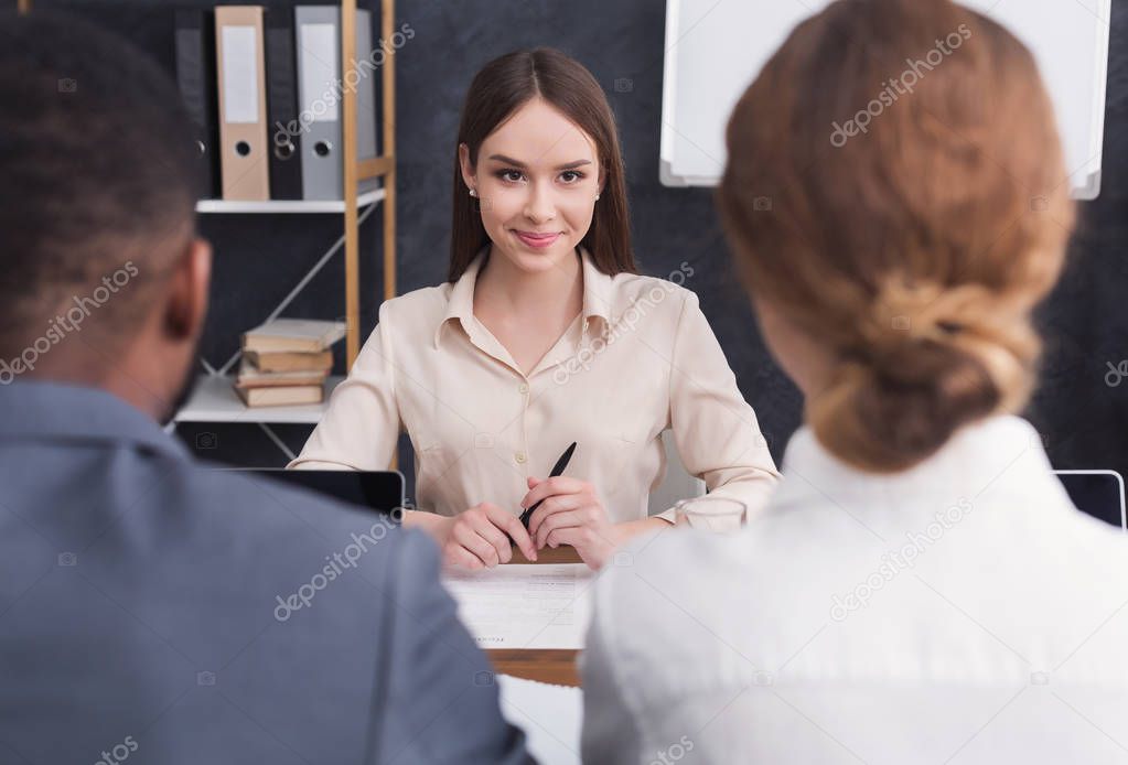 Young woman interviewing by two business people