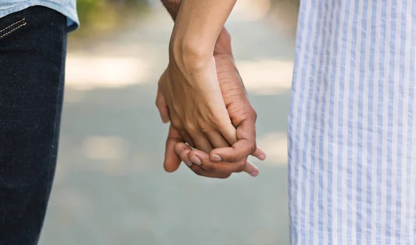 Coppia afro-americana che si tiene per mano mentre cammina nel parco — Foto Stock