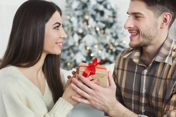 Красивий чоловік дивує дівчину різдвяним подарунком — стокове фото