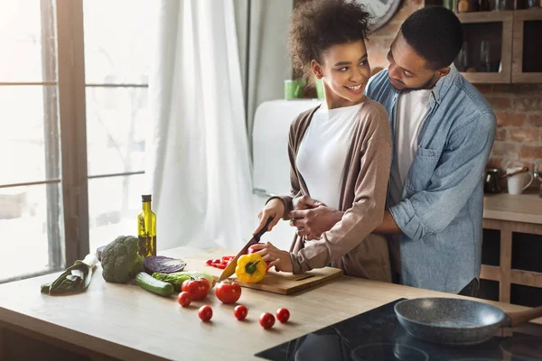 Mencintai suami kulit hitam memeluk istri saat memasak — Stok Foto