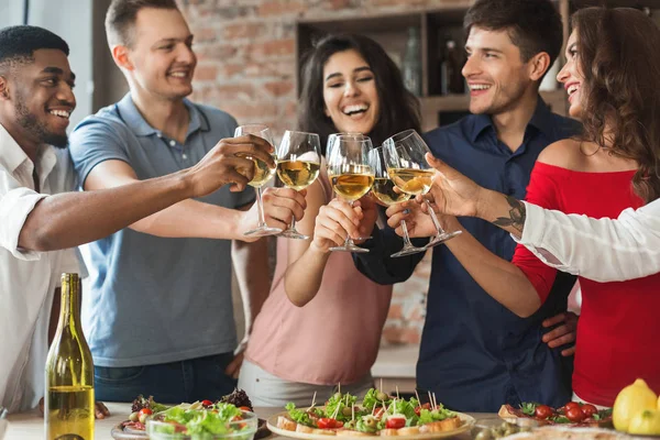 Happy vrienden juichen met glazen witte wijn — Stockfoto