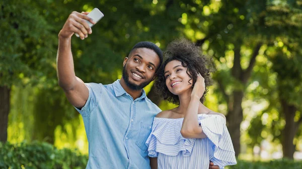 陽気な素敵なカップルが一緒にポーズとスマート フォン屋外で Selfie を作って — ストック写真