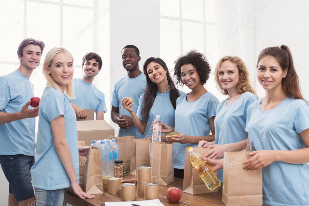 Volunteers putting food and drinks into paper bags