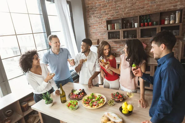 Amigos multirraciais conversando e desfrutando de festa em casa — Fotografia de Stock