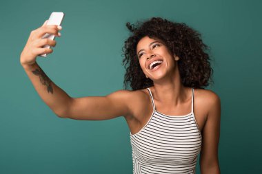 Selfie arka plan üzerine alarak Afrikalı-Amerikalı kadın gülüyor