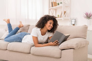 Güzel Afrikalı-Amerikalı kız evde kitap okuma