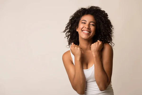 Glückliches schwarzes Mädchen feiert ihren Erfolg auf hellem Hintergrund — Stockfoto