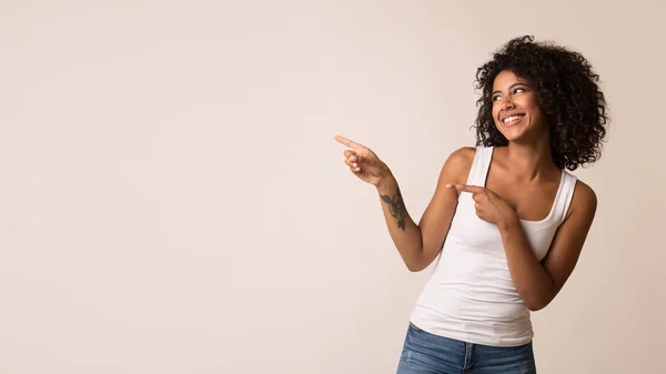 Feliz mulher afro-americana apontando para o espaço de cópia — Fotografia de Stock