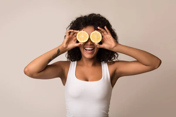 Mulher afro-americana com metades de limão perto dos olhos — Fotografia de Stock