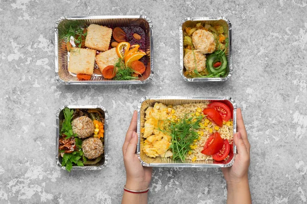 灰色の背景においしい食べ物と箔容器 — ストック写真