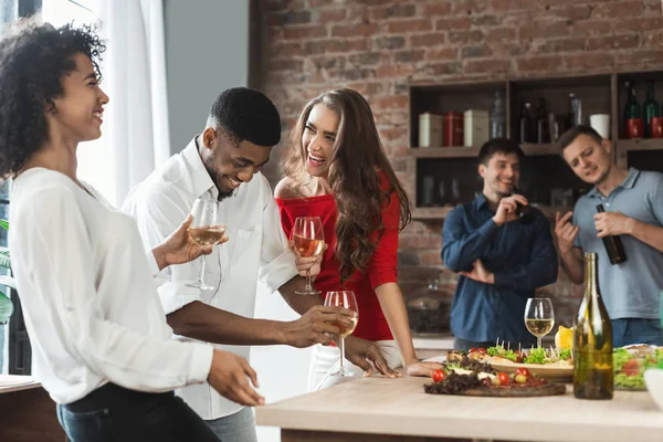 Amigos excitados bebendo e rindo na cozinha — Fotografia de Stock