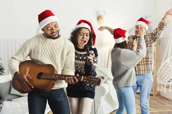 Amigos felizes cantando juntos e tocando na guitarra — Fotografia de Stock