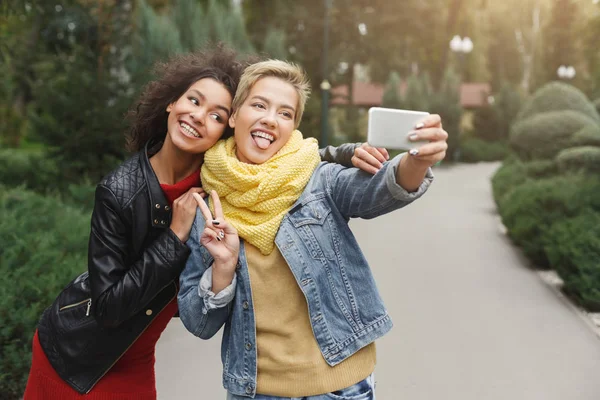 Chicas felices con teléfono inteligente al aire libre en el parque —  Fotos de Stock