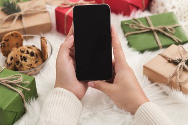 Noel uygulama. Smartphone mockup, kopya alanı kullanan kadın