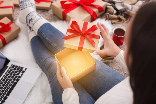 Holiday magic. Woman opening present box at home