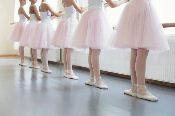 Ballet dancers standing near ballet barre in basic position — Stock Photo, Image