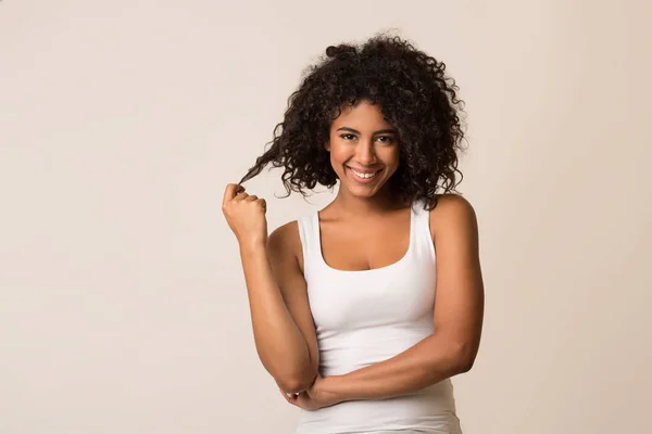 Sorrindo mulher afro-americana flertando sobre fundo claro — Fotografia de Stock