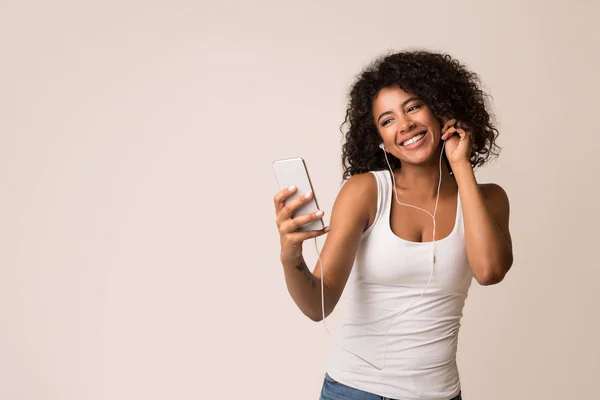 Podekscytowany kobieta korzystających muzyki w słuchawkach na smartphone — Zdjęcie stockowe