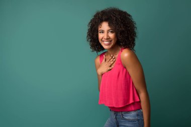 Elini göğsüne tutarak neşeli Afrikalı-Amerikalı kadın