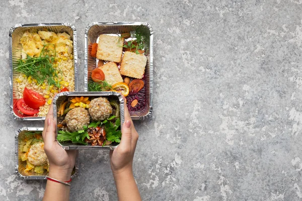 Recipientes de folha com comida deliciosa em fundo cinza — Fotografia de Stock