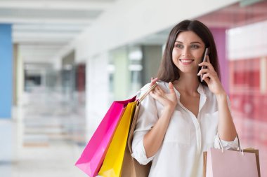 Çarşıda alışveriş yaparken cep telefonu üzerinde konuşurken kadın