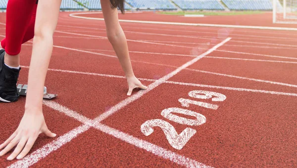 Atleta línea de salida en pista de atletismo con 2019 año — Foto de Stock