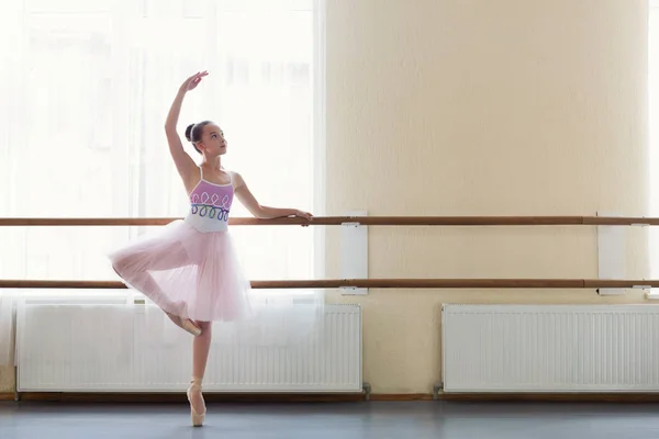 Balerina muda berdiri di atas poite di barre di kelas balet — Stok Foto
