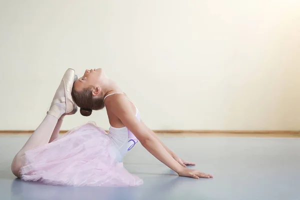 Little ballerina stretching before performance in ballet class — Stock Photo, Image