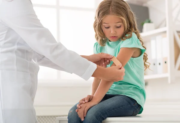 Zszokowana dziewczyna o lekarz pediatra w klinice — Zdjęcie stockowe