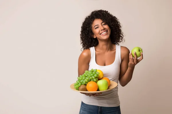 Mujer sosteniendo fruta surtido servido en el plato — Foto de Stock