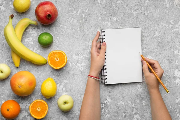 Gezonde voeding. Vrouw hand schrijven in lege notitieblok — Stockfoto